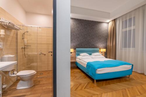 a bedroom with a bed and a shower and a toilet at Medos Hotel in Budapest