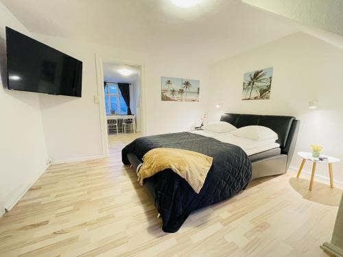 a bedroom with a bed and a flat screen tv at aday - Randers Elegant and Trendy Apartment in Randers