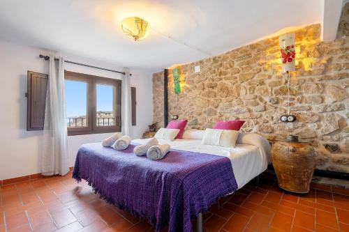 - une chambre avec un lit et un mur en pierre dans l'établissement Ca la Llum, à Tivissa