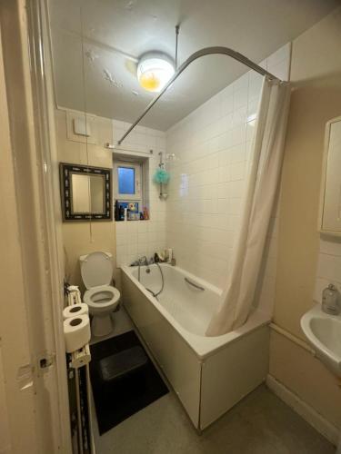 een badkamer met een bad, een toilet en een wastafel bij Highgate Hill Room! in Londen