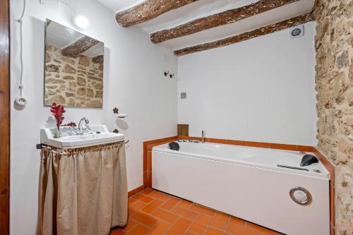 La salle de bains est pourvue d'une baignoire blanche et d'un lavabo. dans l'établissement Ca la Llum, à Tivissa