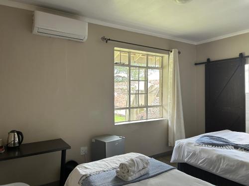 a room with two beds and a window at Monica's Premium Guesthouse in Welkom