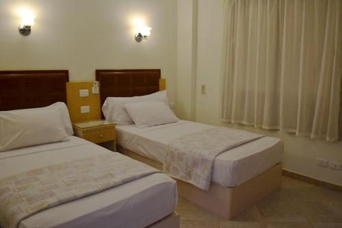 a hotel room with two beds and a window at Sharks Bay apartments for rent in Sharm El Sheikh