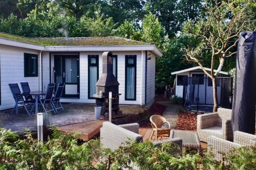 a backyard with a wooden deck with a stove at Chalet Forest Putten even lekker weg. in Putten