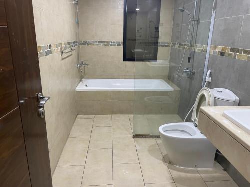 y baño con aseo, bañera y lavamanos. en Heart of Abu Dhabi - Luxury Room, en Abu Dabi