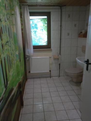 a bathroom with a toilet and a window at Schäferwagen Hotzenplotz 