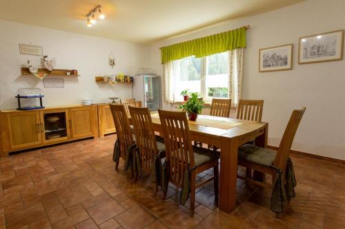 a kitchen with a dining room table and chairs at Ferienhaus 'am Berg' in Fehrenbach