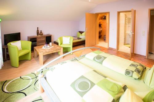 a living room with a glass table and green chairs at Ferienhaus 'am Berg' in Fehrenbach