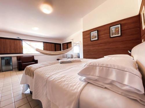 um quarto com uma grande cama branca num quarto em RESERVA DO PAIVA - A MELHOR CASA PARA TEMPORADA em Recife