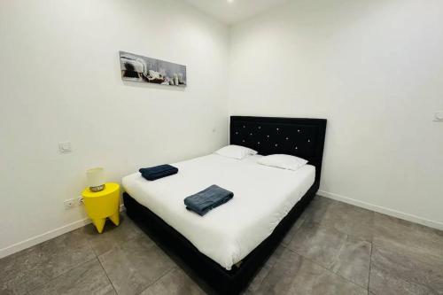 - une chambre avec un lit noir et blanc et une table jaune dans l'établissement Remarkable 2-Bed Apartment in Bordeaux, à Bordeaux