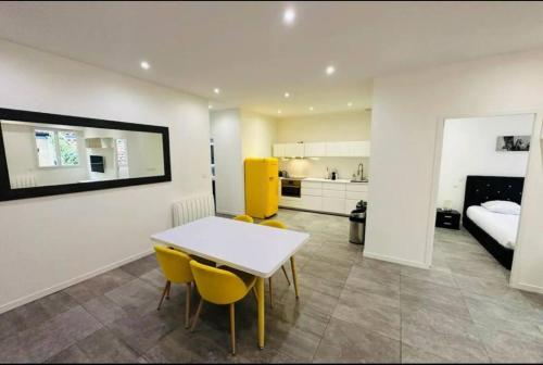 Cette chambre comprend une table, des chaises jaunes et un lit. dans l'établissement Remarkable 2-Bed Apartment in Bordeaux, à Bordeaux