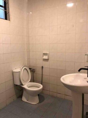 a bathroom with a toilet and a sink at Dahlia Homestay (Wi-Fi & Netflix) in Miri