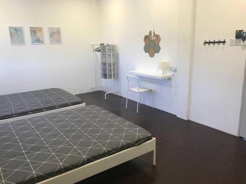 a room with two beds and a table and a desk at Dahlia Homestay (Wi-Fi & Netflix) in Miri