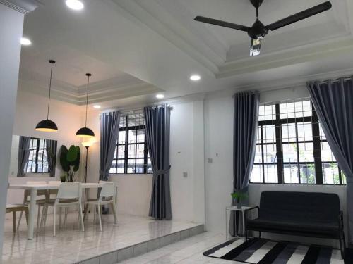 a living room with a table and chairs and windows at Dahlia Homestay (Wi-Fi & Netflix) in Miri