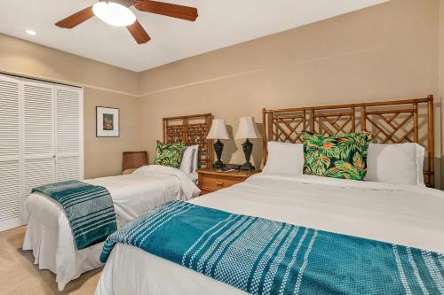 a bedroom with two beds and a ceiling fan at Makena Surf G-201 - End Unit, Panoramic Views, AC! in Wailea