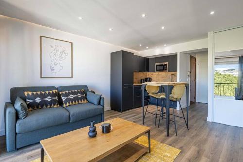 un salon avec un canapé et une table dans l'établissement 8 MERLE - Beau studio au centre de Cannes avec balcon !, à Cannes