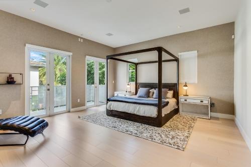 Schlafzimmer mit einem Bett und einem großen Spiegel in der Unterkunft Villa Roxi in Miami