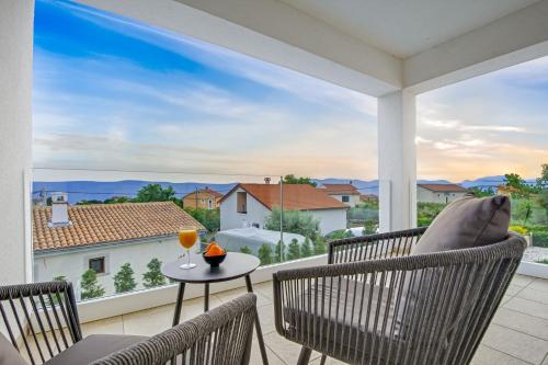 a balcony with chairs and a table with a glass of wine at Villa Insula in Linardići