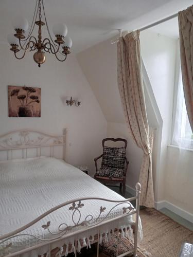 バニョール・ドゥ・ロルヌにあるAppartements Villa Odetteのベッドルーム(白いベッド1台、椅子付)