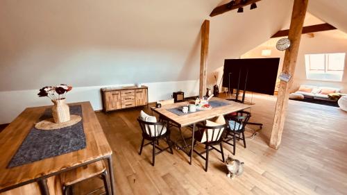 a living room with a table and chairs and a television at Der Hof am Wald in Weichselbaum