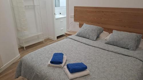 Un dormitorio con una cama con toallas azules. en nuevo refugio en los bajos de Moncloa!, en Madrid