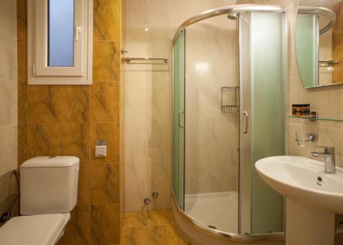 a bathroom with a shower and a toilet and a sink at Kyniska Hotel in Plitra