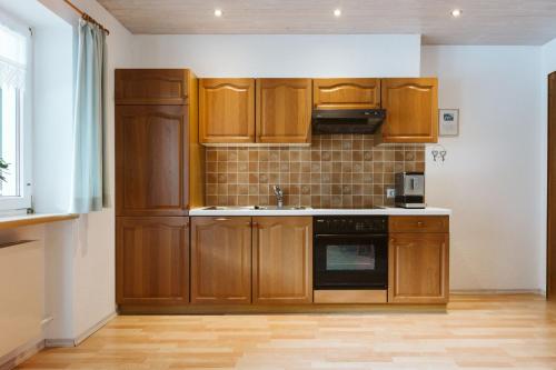 a kitchen with wooden cabinets and a sink at Apartment Dietrich Sylvia in Mellau