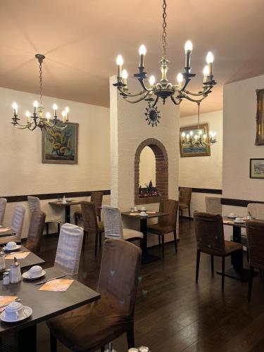 a dining room with tables and chairs and a chandelier at Hotel Schnookeloch in Heidelberg