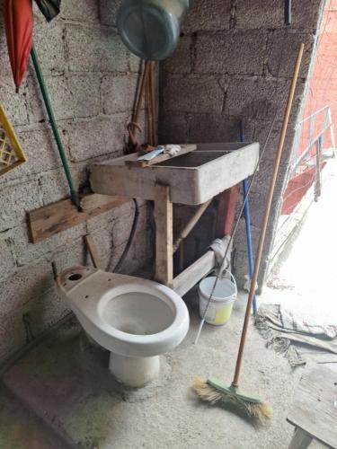 a dirty bathroom with a toilet and a sink at CUARTOS A PIE DE CARRETERA MEXICO-TEOTIHUACAN in Tepexpan