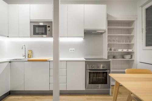 a kitchen with white cabinets and a stove top oven at 1 bedrooms 1 bathroom furnished - La Latina - modern - MintyStay in Madrid