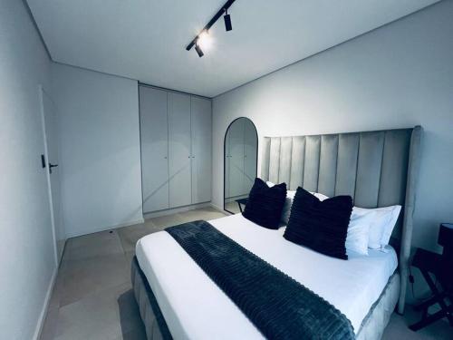 een slaapkamer met een groot bed met blauwe kussens bij City Sky Line View .Melrose,Rosebank ,Sandton in Johannesburg