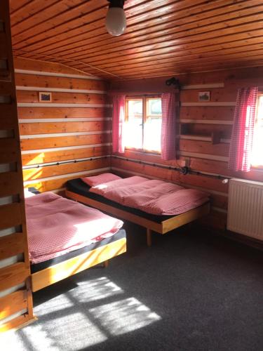 a room with two beds in a wooden cabin at chata Školička in Horni Misecky