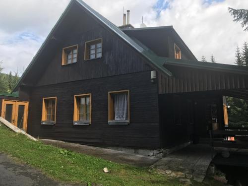 a black house with a gambrel roof at chata Školička in Horni Misecky