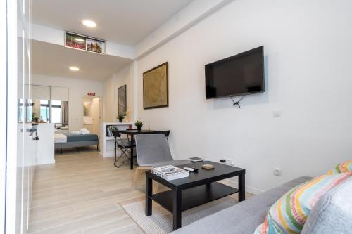 a living room with a couch and a tv on a wall at Modern comfy-1bedroom 1bathroom-Prosperidad in Madrid