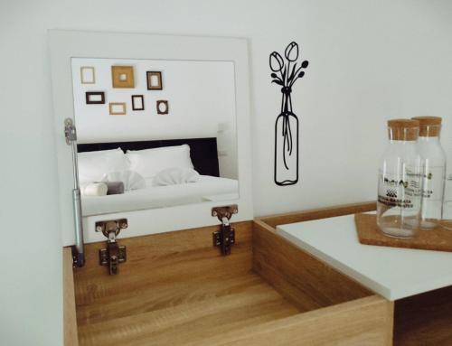 Bagnera51 في روما: غرفة نوم مع سرير و مزهرية على طاولة
