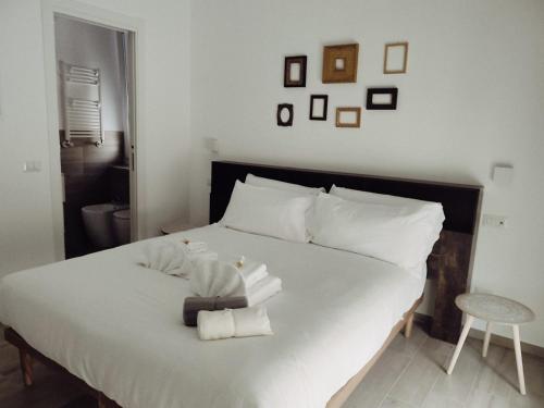 Bagnera51 في روما: غرفة نوم بسرير ابيض عليها مناشف