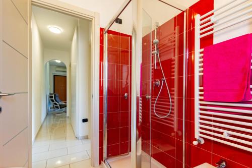 a red bathroom with a shower and red tiles at Appartamento Sandra Trilo - MyHo Casa in Vasto