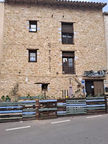 a brick building with a fence in front of it at Ca la Serreta in Cretas