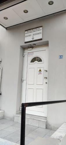 a white door on a building with a sign above it at Skordas Comfy Rent Rooms in Thessaloniki