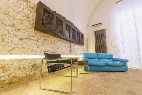 a living room with a blue couch and a chair at Il Granile Contemporary Loft in Matera