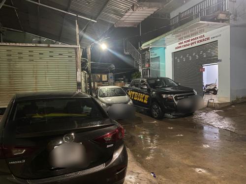 due auto parcheggiate in un garage di notte di Nhà Nghỉ Đoàn Gia a Dồng Xoài