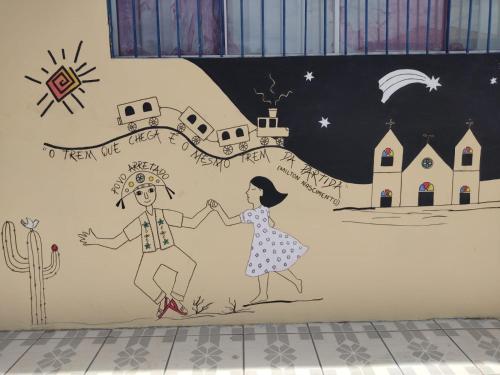 een muurschildering van een jongen en een meisje hand in hand bij SOLAR HOSTEL PARNAIBA in Parnaíba