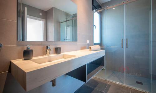 La salle de bains est pourvue d'un lavabo et d'une douche en verre. dans l'établissement TarracoHomes - TH130 Golf y Relax Tarragona Costa Dorada, à Catllar