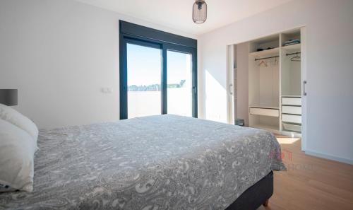 a bedroom with a bed and a large window at TarracoHomes - TH130 Casa Golf Costa Dorada in Catllar