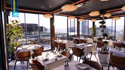een restaurant met witte tafels, stoelen en ramen bij Hotel De Reve Galata-Special Class in Istanbul