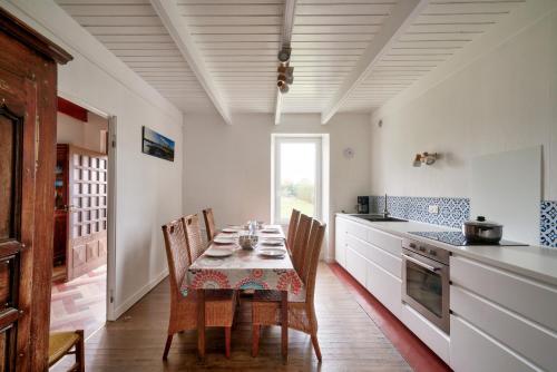 une salle à manger avec une table et des chaises dans une cuisine dans l'établissement Pays bigouden - Charmante maison en pierre pour 6, à Tréffiagat