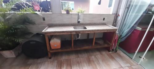 un bagno con lavandino e alcune piante in vaso di Casa a 300 metros da Praia da Pinheira ,3 km da Guarda do Embaú Sc a Palhoça