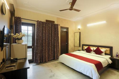 a bedroom with a large bed and a television at Hotel The Sunrise View - Corporate Stay Hotel in Noida