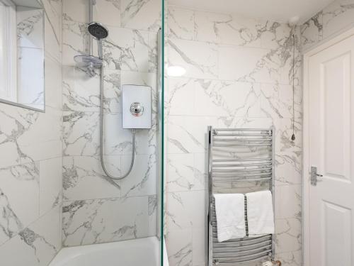 a bathroom with a shower with white marble walls at Pass the Keys Stylish Flat with Free Parking in Reading