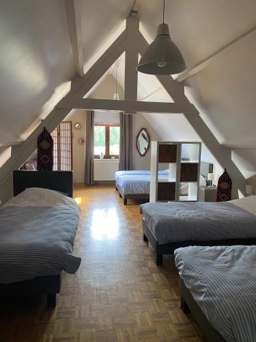 a room with three beds in a room at Hof van Kalenberg in Borgloon